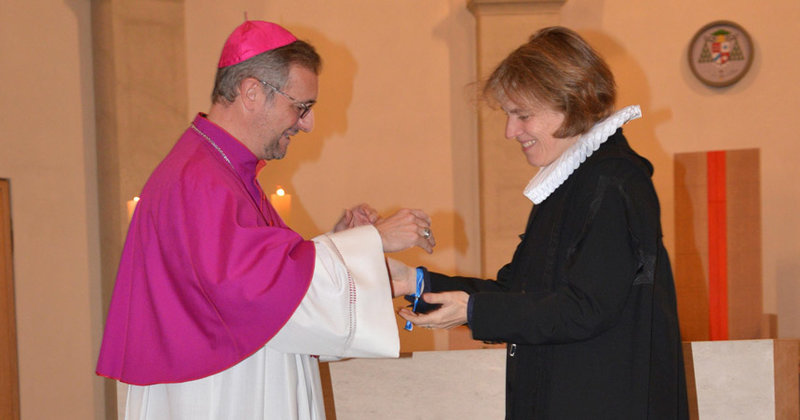 Auch Erzbischof Stefan Heße und Pöpstin Astrid Kleist binden sich gegenseitig Friedensbändchen um