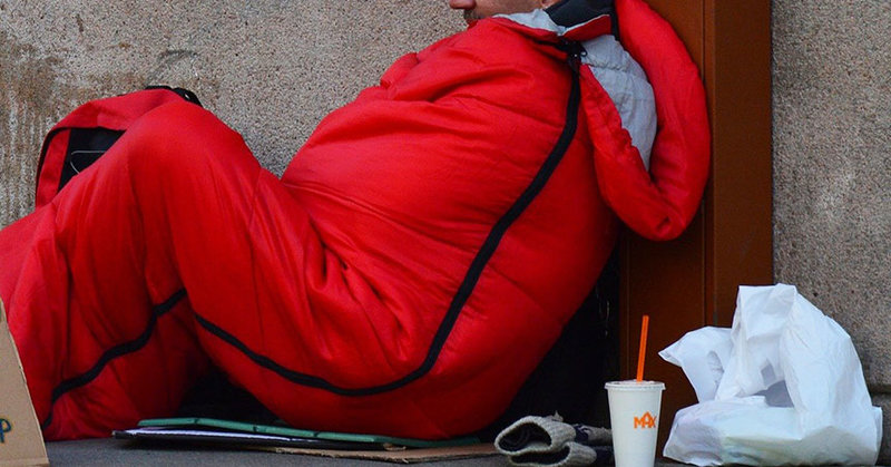 Obdachloser im Schlafsack auf der Straße