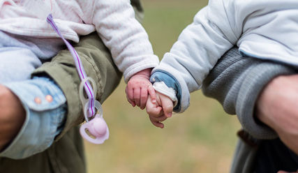 Zwei Babies auf den Armen ihrer Eltern - Copyright: © Creative Commons