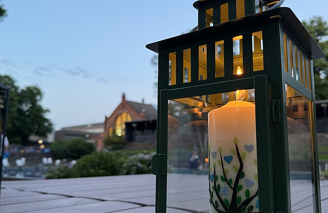 Eine Kerze steht auf dem Tisch bei einer Freilufftaufe