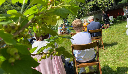 Menschen auf Klappstühlen im Garten - Copyright: Janna Horstmann