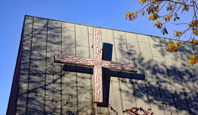 Außenansicht der Emmauskirche: Kreuz am Kirchengebäude - Copyright: Karen Diehn
