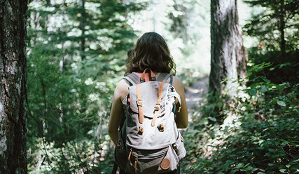 Eine Frau wandert durch den Wald - Copyright: Unsplash
