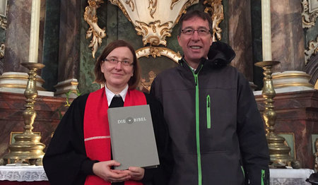 Pastorin Iris Finnern nimmt in Rellingen die neue Altarbibel aus den Händen von Propst Thomas Drope in Empfang