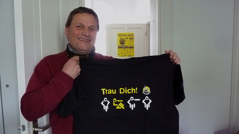 "Trau Dich!": MOGO-Pastor Lars Lemke zeigt ein T-Shirt mit dem MOGO-Motto 2015