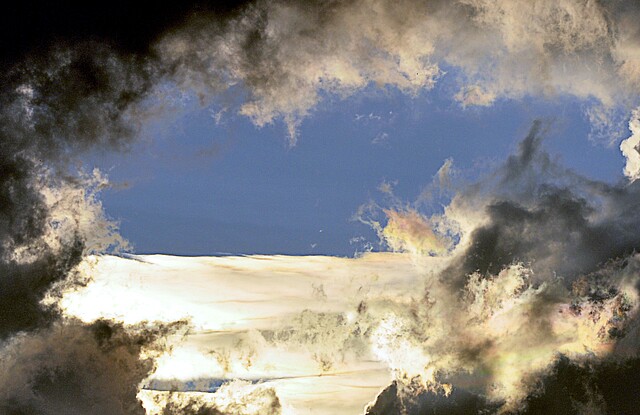 Dunkle Wolken reißen auf und blauer Himmel ist zu sehen.