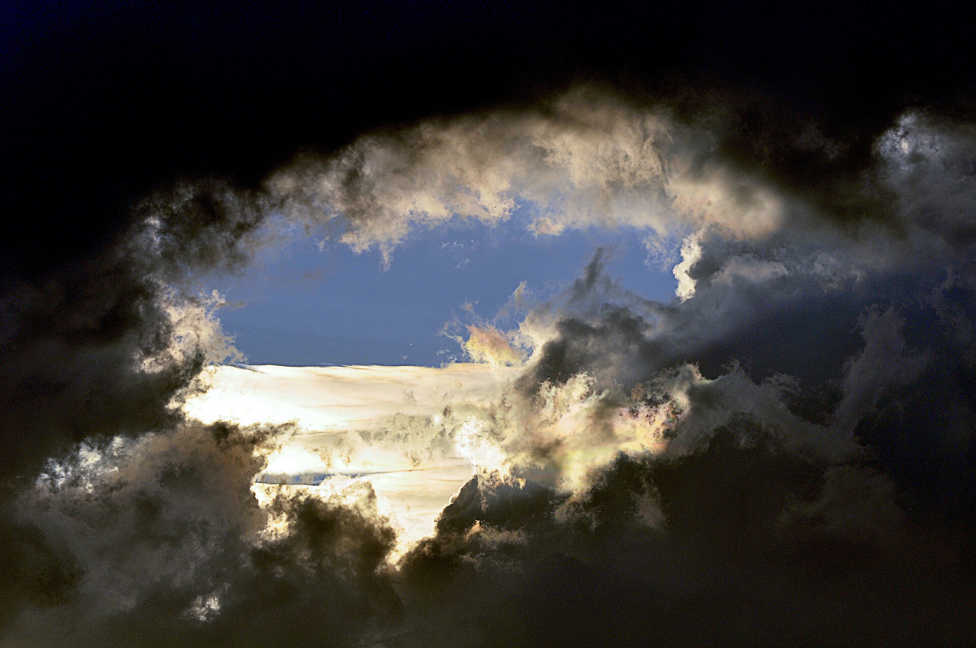 Dunkle Wolken reißen auf und blauer Himmel ist zu sehen.