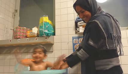 Badespaß: Nia genießt das warme Wasser und ihre Mutter Maryam freut sich - Copyright: Sabine Henning/kirche-hamburg.de