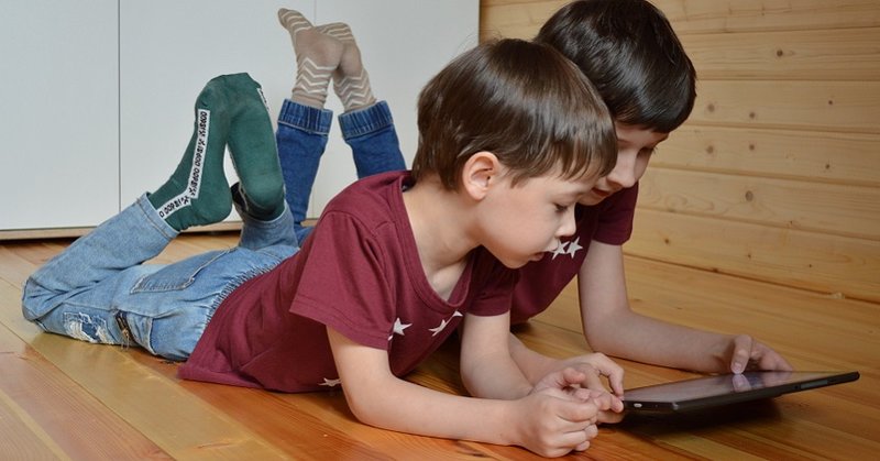 Zwei Kinder schauen auf ein Tablet
