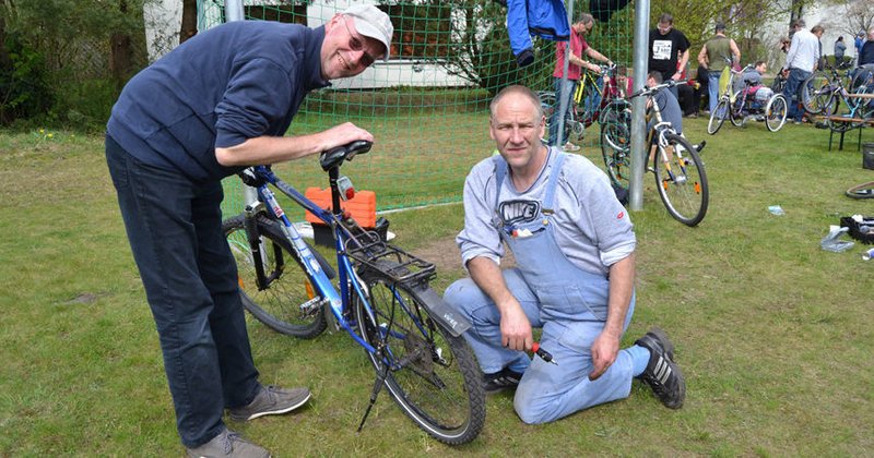 Tim Löschenkohl (l.) repariert mit Michael Schlegel dessen Fahrrad