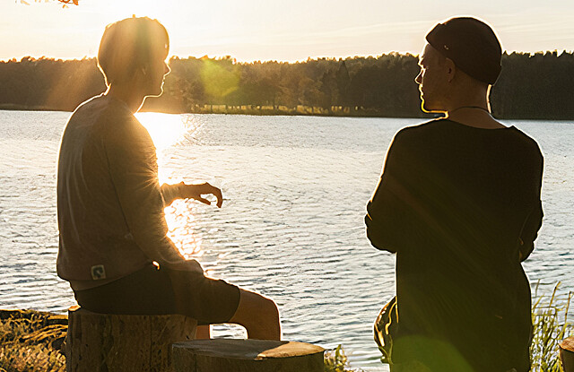 Zwei sich unterhaltende Personen bei Sonnenuntergang