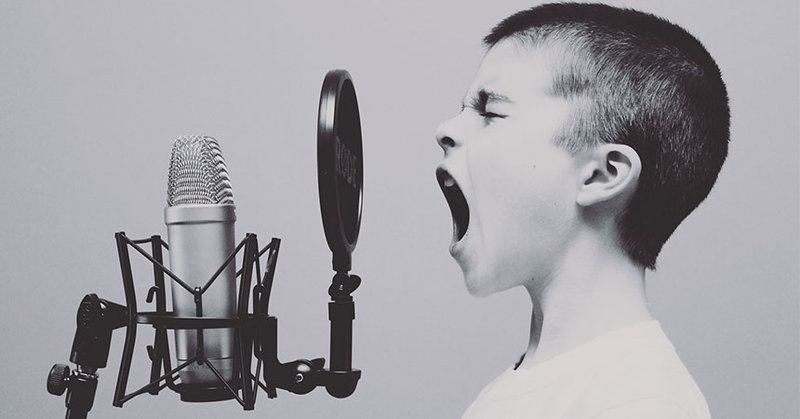 Ein Junge schreit in ein Mikrofon