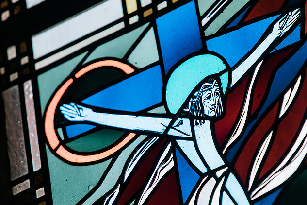 Ein Kirchenfenster zeigt Jesus am Kreuz