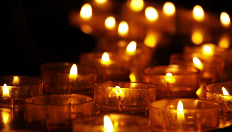Eine Reihe von brennenden Kerzen in einer Kirche