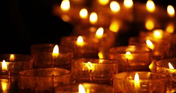 Eine Reihe von brennenden Kerzen in einer Kirche - Copyright: NoName_13 / pixabay