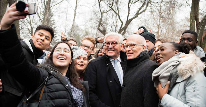 Bürgermeister Peter Tschentscher und Bundespräsident Frank-Walter Steinmeier machen mit einer Gruppe Jugendlicher ein Selfie.