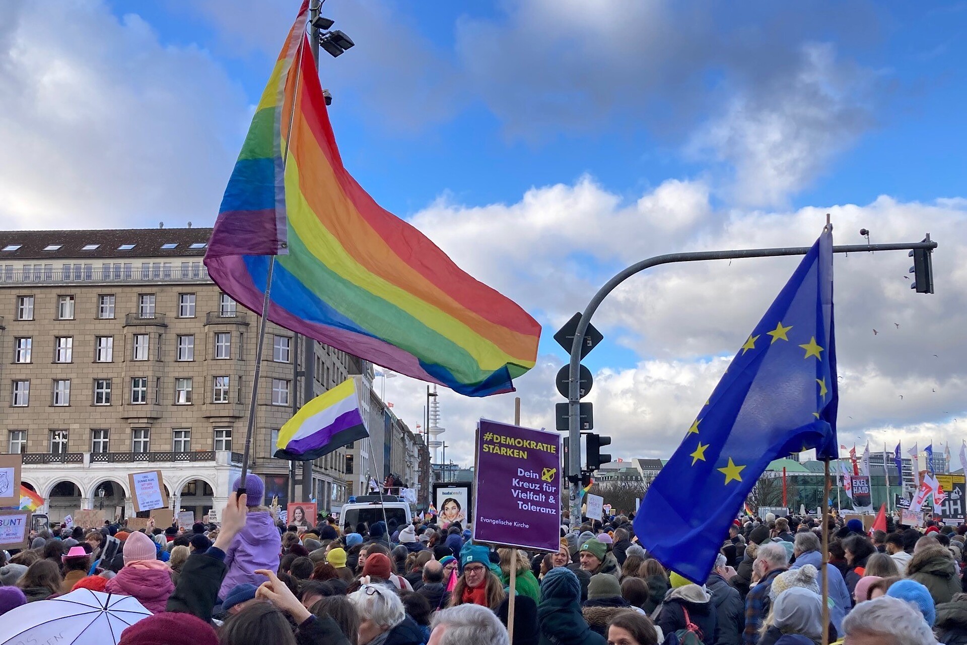 Menschenmenge und Fahnen bei einer Demonstration in Hamburg für Demokratie.