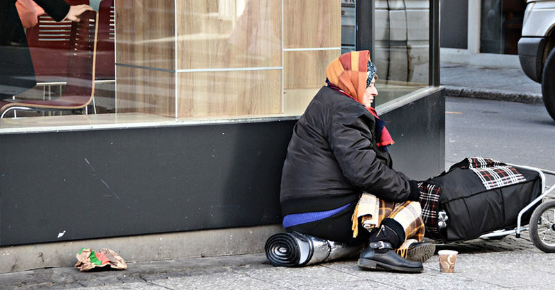 Eine obdachlose Frau vor einem Restaurant