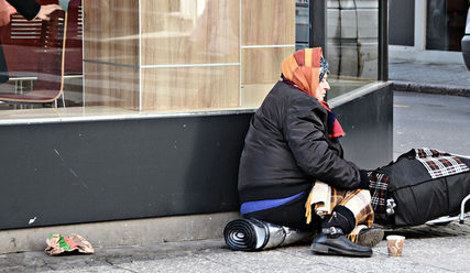 Eine obdachlose Frau vor einem Restaurant - Copyright: © Creative Commons
