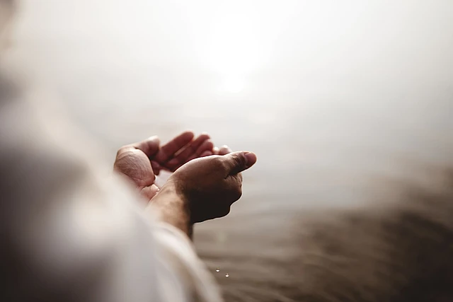 Zwei Hände über Wasser in einer spirituellen Anmutung. 