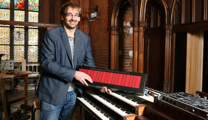 Organist Christoph Bender mit einem neuen Keyboard, das auch in die Orgel eingebaut wurde - Copyright: Stephan Wallocha/epd-bild