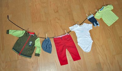 Wäscheleine, an der Kinderkleidung befestigt ist - Copyright: Daniela Steinke