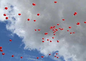 Rote Luftballons fliegen in Himmel
