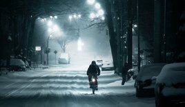 Ein Mensch fährt durch eine verschneite Straße auf dem Fahrrad - Copyright: Marcel Köhler / pexels