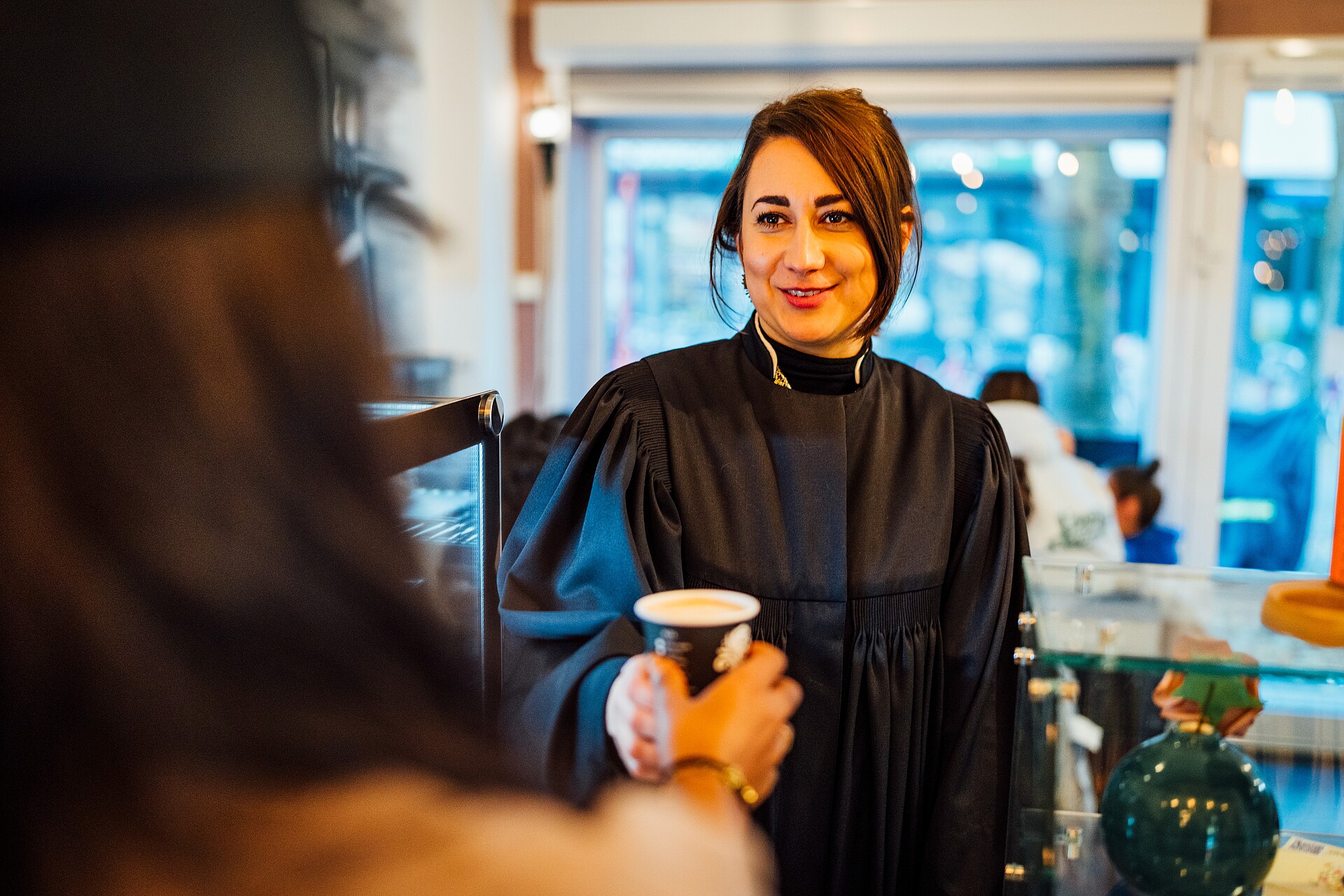 Eine junge Frau, Rebecca Assif, erhält einen Kaffee to Go
