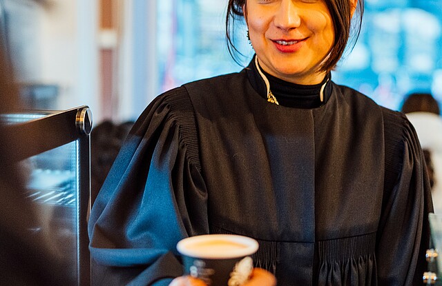 Eine junge Frau, Rebecca Assif, erhält einen Kaffee to Go