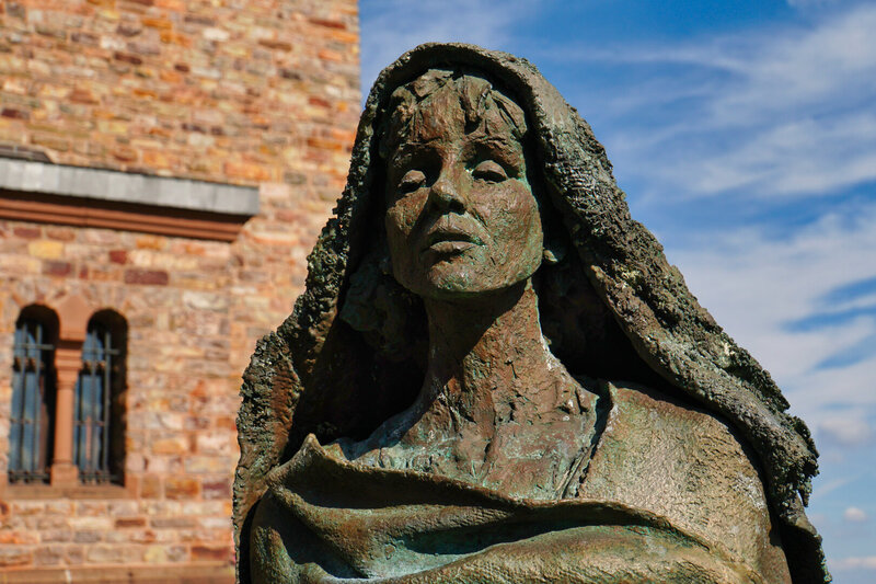 Die Statue einer Frau steht vor einem Gebäude