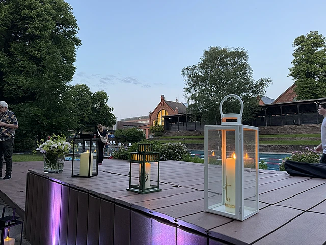 Kerzen stehen in einer Reihe bei der Freilufttaufe