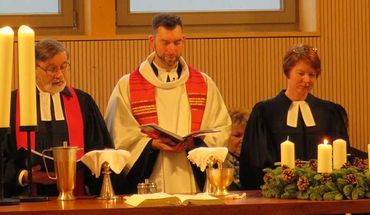 Die drei Geistlichen der Kirchengemeinde Quickborn-Hasloh am Altar der neuen Kirche: Rainer Patz, Florian Niemöller und Claudia Weisbarth (v.l.) – ©Hartmut Ermes