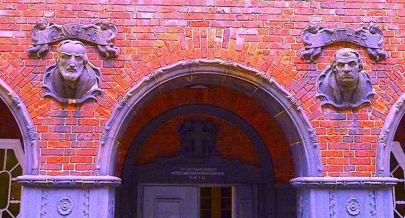 Das Portal der Auferstehungskirche in Barmbek-Nord zieren Keramikbüsten der Reformatoren Martin Luther und Philipp Melanchthon - hier ein coloriertes Bild