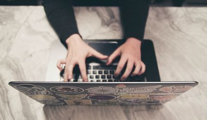 Person tippt auf einer Laptop-Tastatur - Copyright: NeONBRAND/Unsplash 