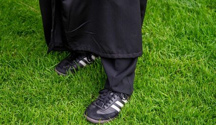 Pastorin Linda Pinnecke trägt passende Schuhe für den TSV-Fußballrasen - Copyright: Karen Diehn