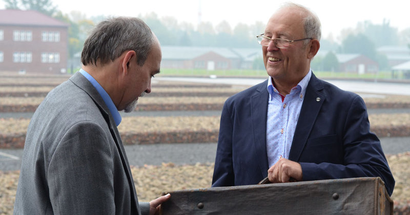 Michael Rosenberg (re.) übergibt den Koffer an Detlef Garbe, den Leiter der KZ-Gedenkstätte Neuengamme