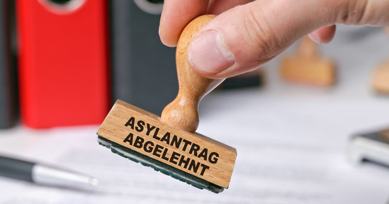 Hand mit Stempel: "Asylantrag abgelehnt"