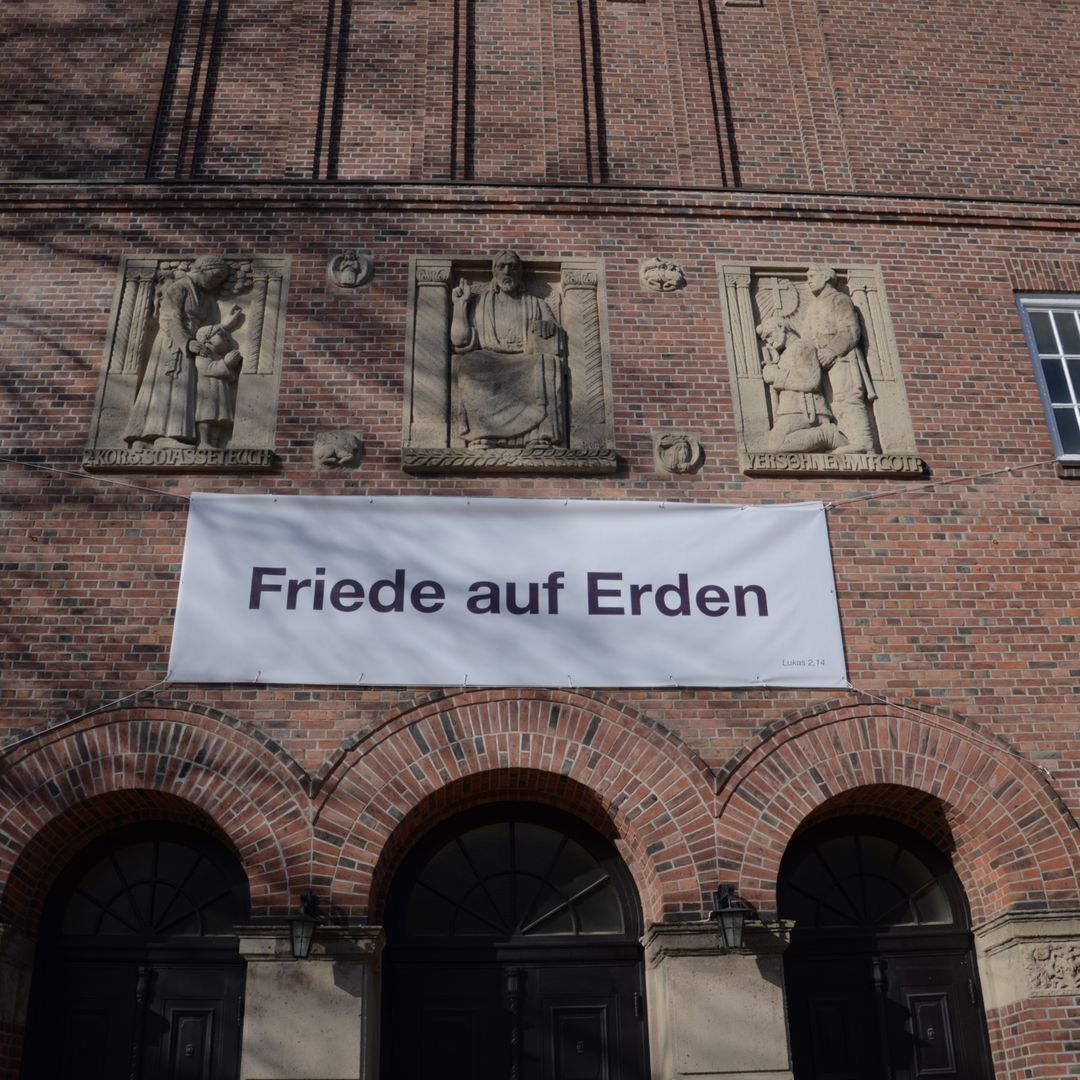Banner an der Versöhnungskirche auf dem steht "Frieden auf Erden"